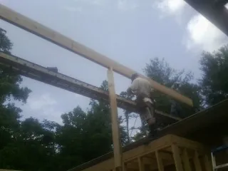 Carpenter setting a ridge beam over a new addition frame — Ice Dam Removal by Roofing Brothers in Saint Clairsville