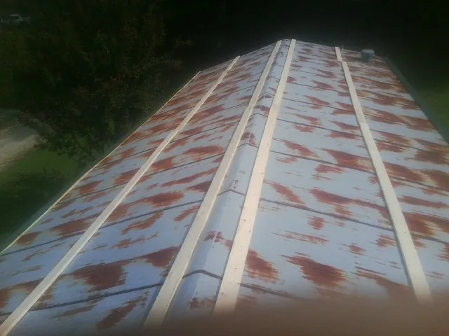 Rusted metal roof panels with new wood purlins before replacement — Storm Damage Roof Repair in Saint Clairsville by Roofing Brothers