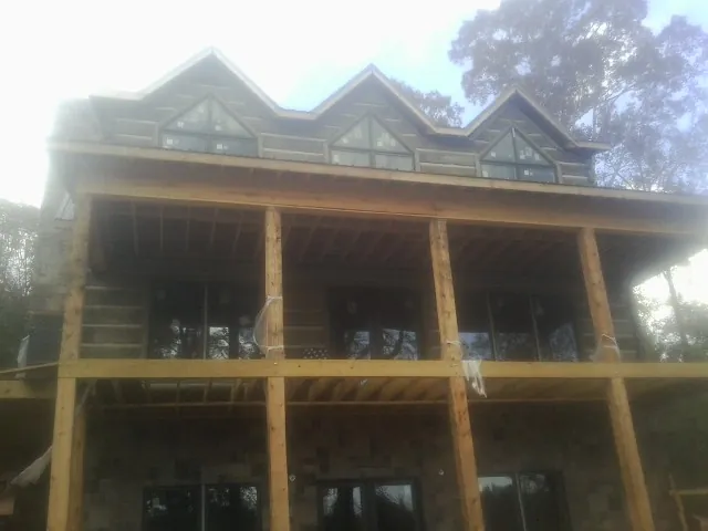 Dormers and porch framing on a large log home under construction — Roof Coating work by our crew in Saint Clairsville