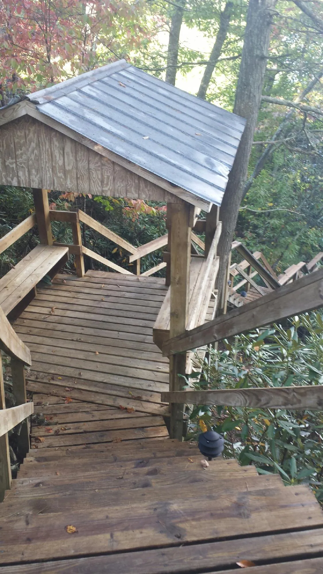 Metal roofed shelter over wooden steps on a wooded walkway — Skylight Repair & Installation work by our crew in Saint Clairsville