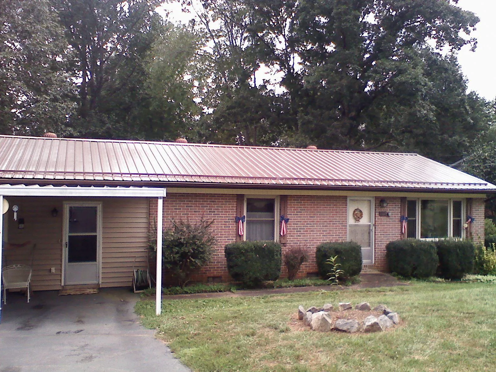 Bronze metal roof and carport on a brick ranch home — Roof Repair work by our crew in Saint Clairsville